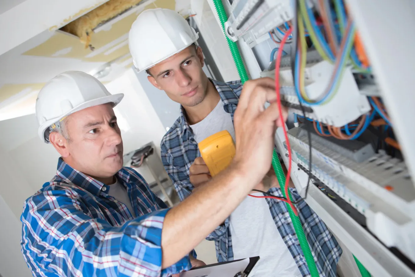 Électricien de Michel Électricité posant l'appareillage sur un chantier du Val-de-Bièvre